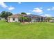 Expansive yard with lush green grass, landscaping, and a screened-in pool area at 5400 Saddleback Ct, Lady Lake, FL 32159