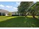 Lush backyard with mature trees, and a well-maintained lawn create a private and serene outdoor space at 5604 Gulf Stream St, Tavares, FL 32778