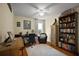 Inviting bedroom featuring a ceiling fan, cozy chair, and a charming bookcase filled with books at 5604 Gulf Stream St, Tavares, FL 32778
