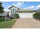 Charming single-story home featuring a two-car garage, beautiful landscaping, and a welcoming facade at 5604 Gulf Stream St, Tavares, FL 32778