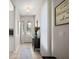 Well-lit hallway with tile flooring, leading to the decorative front door with glass panels at 5604 Gulf Stream St, Tavares, FL 32778