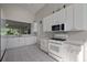 Bright kitchen with white cabinetry, tiled floor, and stainless steel microwave at 5604 Gulf Stream St, Tavares, FL 32778