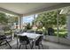 Enclosed patio with comfortable seating, an outdoor dining set, and views of the landscaped backyard at 5604 Gulf Stream St, Tavares, FL 32778