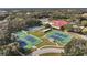 An aerial view showcases tennis courts and bocce ball courts with lush landscaping and mature trees at 5618 Rosewall Cir, Leesburg, FL 34748