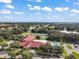 Aerial view of the community center featuring a pool, tennis courts, and clubhouse nestled among lush trees at 5618 Rosewall Cir, Leesburg, FL 34748
