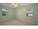 Bedroom with plush carpeting, two windows, and a ceiling fan at 5618 Rosewall Cir, Leesburg, FL 34748