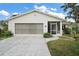 Charming single-story home with a two-car garage, screened front porch, and a well-manicured lawn at 5618 Rosewall Cir, Leesburg, FL 34748