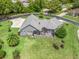 Aerial view of home showing its landscaped backyard with a screened-in patio, surrounded by lush greenery at 563 Dowling Cir, Lady Lake, FL 32159