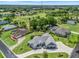Aerial view of home with lush landscaping and well-manicured lawn in a tranquil neighborhood near a golf course at 563 Dowling Cir, Lady Lake, FL 32159