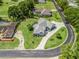 Aerial view of a home showcasing its landscaping, long driveway, and proximity to a golf course and surrounding community at 563 Dowling Cir, Lady Lake, FL 32159
