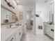 Bright bathroom featuring double vanity, framed mirror, tiled floors, and an open shower area with a wood bench at 563 Dowling Cir, Lady Lake, FL 32159