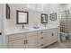 Inviting bathroom featuring double vanity with framed mirrors, and a shower/tub combo with neutral tones at 563 Dowling Cir, Lady Lake, FL 32159