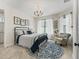 Charming bedroom features a decorative chandelier, accent rug, and sitting area with plush armchair and an abundance of natural light at 563 Dowling Cir, Lady Lake, FL 32159