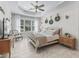 A stylish bedroom with tray ceiling, large window, and neutral tones creating a relaxing atmosphere at 563 Dowling Cir, Lady Lake, FL 32159