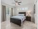 Bedroom with ceiling fan, tile floors, large window and wood nightstand with lamp at 563 Dowling Cir, Lady Lake, FL 32159