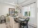 Bright dining room featuring a dark wood table set for six, an elegant chandelier, and white curtains at 563 Dowling Cir, Lady Lake, FL 32159