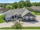 Stunning single-story home featuring a well-manicured lawn and a neutral color scheme exterior at 563 Dowling Cir, Lady Lake, FL 32159