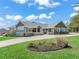 Inviting single-story home featuring a manicured lawn, stone accents, and a concrete driveway at 563 Dowling Cir, Lady Lake, FL 32159