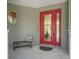 Inviting front porch featuring a red glass front door, bench, and neutral accents at 563 Dowling Cir, Lady Lake, FL 32159