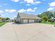 Wide driveway leading to the attached two-car garage of a well-maintained house with manicured landscaping and green lawns at 563 Dowling Cir, Lady Lake, FL 32159