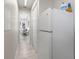 Hallway view with an additional refrigerator, leading to a dining area with a table and chairs at 563 Dowling Cir, Lady Lake, FL 32159