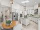 Bright, spacious kitchen with white cabinetry, a large island with granite countertops, and high ceilings with pendant lighting at 563 Dowling Cir, Lady Lake, FL 32159