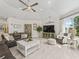 The living room includes tile flooring, a ceiling fan, a sofa, and a large window at 563 Dowling Cir, Lady Lake, FL 32159