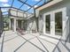 Screened-in patio with comfortable seating area, perfect for outdoor relaxation and entertaining near the home's double doors at 563 Dowling Cir, Lady Lake, FL 32159