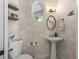 Charming powder room with decorative wallpaper, pedestal sink, and stylish fixtures at 563 Dowling Cir, Lady Lake, FL 32159