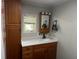 Bathroom with oak cabinets, quartz counters, and light sconces at 606 Hamilton Dr, Orlando, FL 32833