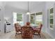 Bright breakfast nook with natural light from large windows, featuring a glass table and comfortable seating at 627 Leeds Pl, The Villages, FL 32162