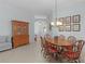 Formal dining room boasts a wood table, chandelier lighting, and a built-in wood china cabinet for sophisticated entertaining at 627 Leeds Pl, The Villages, FL 32162
