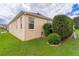 Side view of house featuring manicured lawn, trimmed hedges and an exterior water fixture at 627 Leeds Pl, The Villages, FL 32162