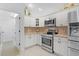Well-equipped kitchen with stainless steel appliances, light cabinets, and adjacent doorway for convenient access at 627 Leeds Pl, The Villages, FL 32162