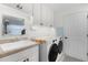 Efficient laundry room with white cabinetry, countertop folding area, and a utility sink at 627 Leeds Pl, The Villages, FL 32162
