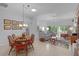 Bright living room features a skylight, neutral tile, comfortable seating, and views of the outdoor living space at 627 Leeds Pl, The Villages, FL 32162