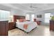 Serene main bedroom features a tray ceiling, ceiling fan, large windows, and warm, inviting decor at 627 Leeds Pl, The Villages, FL 32162