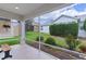Enclosed porch showing an outdoor sitting area with views of the green, landscaped backyard at 627 Leeds Pl, The Villages, FL 32162