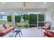 Relaxing screened porch with comfortable seating, offering views of the beautifully landscaped backyard at 627 Leeds Pl, The Villages, FL 32162