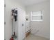 Neat storage area with white cabinets, drawers, and a vacuum cleaner hanging on the wall at 627 Leeds Pl, The Villages, FL 32162