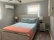 Comfortable bedroom with stylish decor, featuring a queen-sized bed, side tables, and window at 640 Mansfield Rd, Tavares, FL 32778