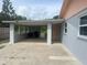 Covered carport is attached to the side of the house with laundry room door access at 640 Mansfield Rd, Tavares, FL 32778