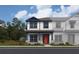 Charming two-story home showcasing a vibrant orange front door and inviting covered porch at 6476 Barnstorm Way, St Cloud, FL 34771