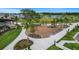 Aerial shot of a community playground with swings, slides, and a picnic area near a pond at 6476 Barnstorm Way, St Cloud, FL 34771