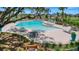 Inviting community pool area with plenty of lounge chairs and tables for relaxing poolside in a beautiful landscaped setting at 6488 Barnstorm Way, St Cloud, FL 34771