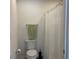 Bathroom with a toilet, shower with decorative curtains, a towel rack, and neutral walls at 680 Joseph Way, The Villages, FL 34762