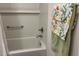 Bright bathroom featuring a bathtub with white subway tile and a decorative floral towel at 680 Joseph Way, The Villages, FL 34762