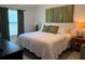 Cozy bedroom with a queen-sized bed, green accents, and ample natural light at 680 Joseph Way, The Villages, FL 34762