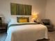 Bright bedroom with green and yellow accents, a cozy chair, and unique artwork at 680 Joseph Way, The Villages, FL 34762