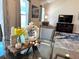 Dining area with a glass table, stylish decor, and a view into the cozy living room at 680 Joseph Way, The Villages, FL 34762